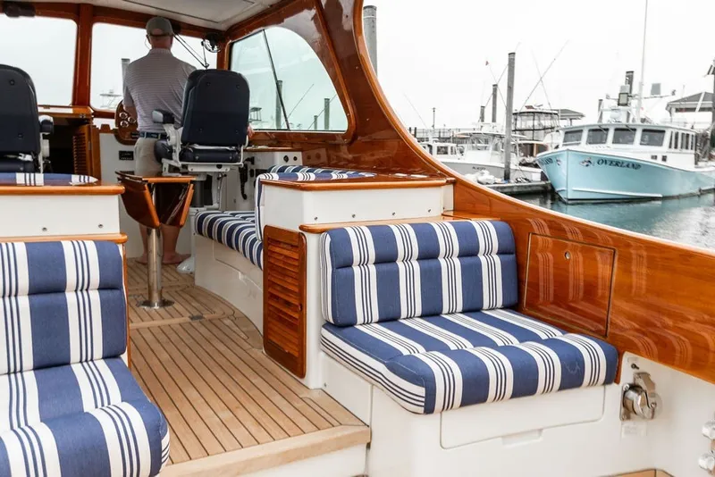 Slide: The Image of Interior of 2012 Hinckley Picnic Boat MKIII with striped seating and wooden finishes at a marina. - 30