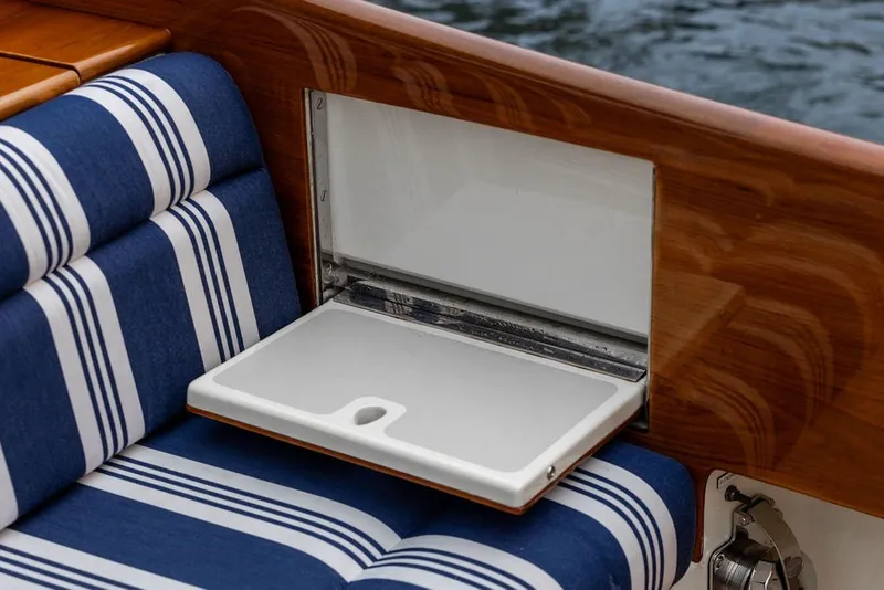 Slide: The Image of Hinckley Picnic Boat MKIII 2012 interior with striped seating and fold-out table. - 25