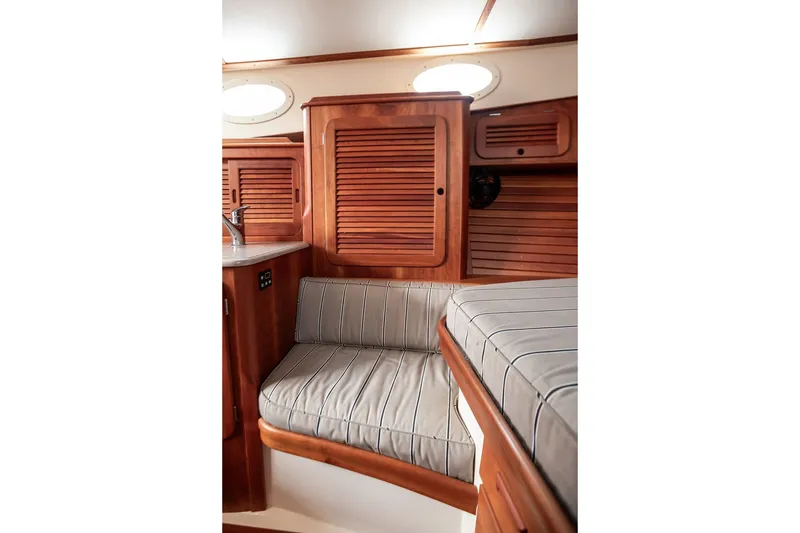 Slide: The Image of Interior of 2012 Hinckley Picnic Boat MKIII with wooden cabinetry and cushioned seating. - 21