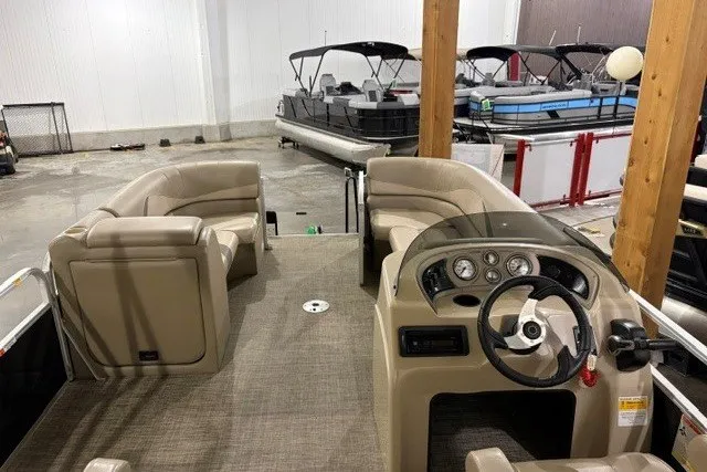 Slide: The Image of 2015 SunCatcher V22 RC pontoon boat interior with beige seating and steering console. - 4
