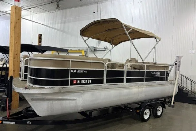 The Image of 2015 SunCatcher V22 RC pontoon boat with canopy on trailer in indoor showroom. - 0