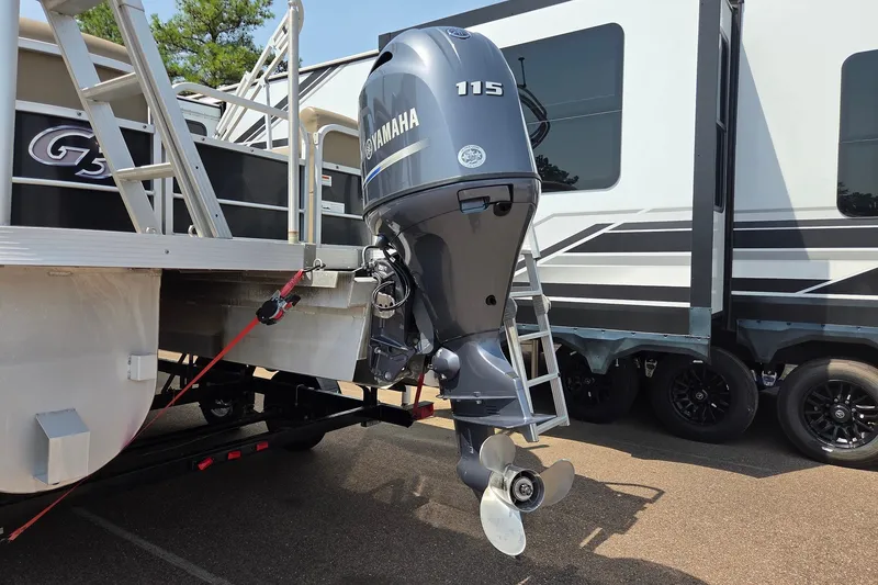 Slide: The Image of SunCatcher V22 RC 2015 boat with Yamaha 115 outboard motor, parked beside a trailer. - 2