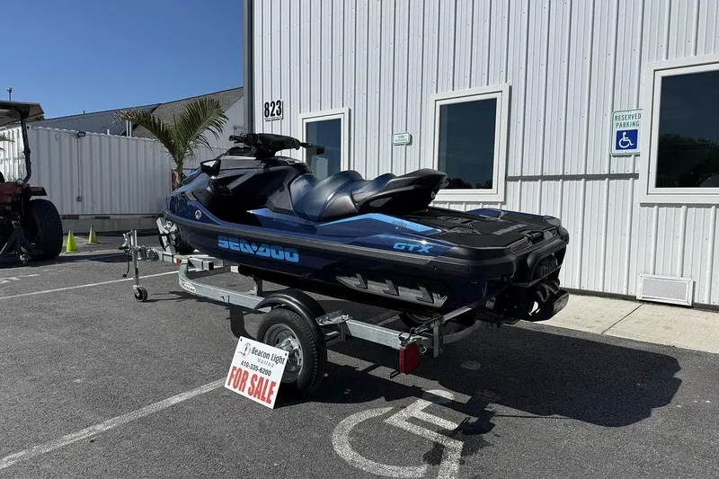 Slide: The Image of 2024 Sea-Doo GTX 230 jet ski on trailer, parked outside, for sale sign visible. - 4