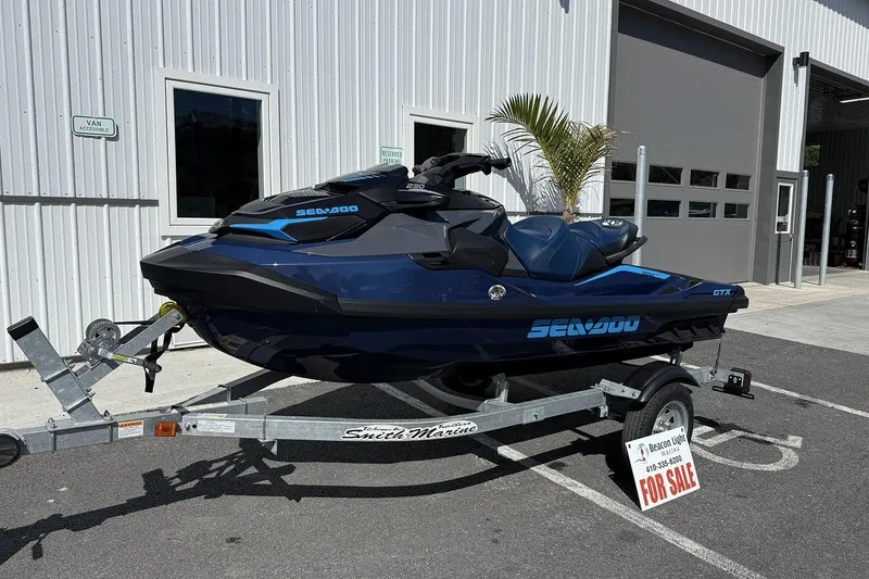 Slide: The Image of 2024 Sea-Doo GTX 230 jet ski on trailer, parked outside dealership, for sale sign visible. - 1
