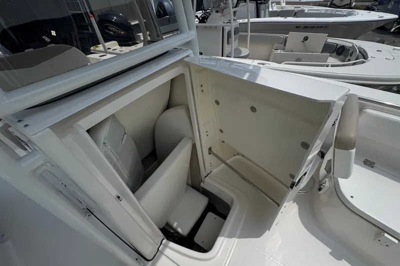 Slide: The Image of 2023 Robalo R200 Center Console boat storage compartment open, showcasing interior space. - 17