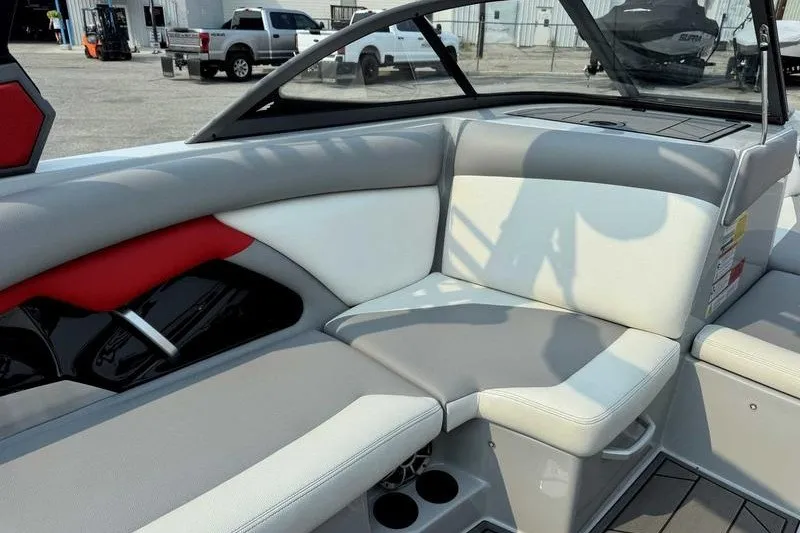 Slide: The Image of 2018 Tigé R21 boat interior with gray and white seating, cup holders, and modern design. - 16