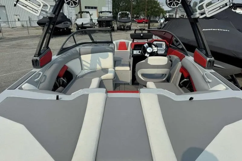 Slide: The Image of 2018 Tigé R21 boat interior with gray and red seating, steering wheel, and speakers. - 4