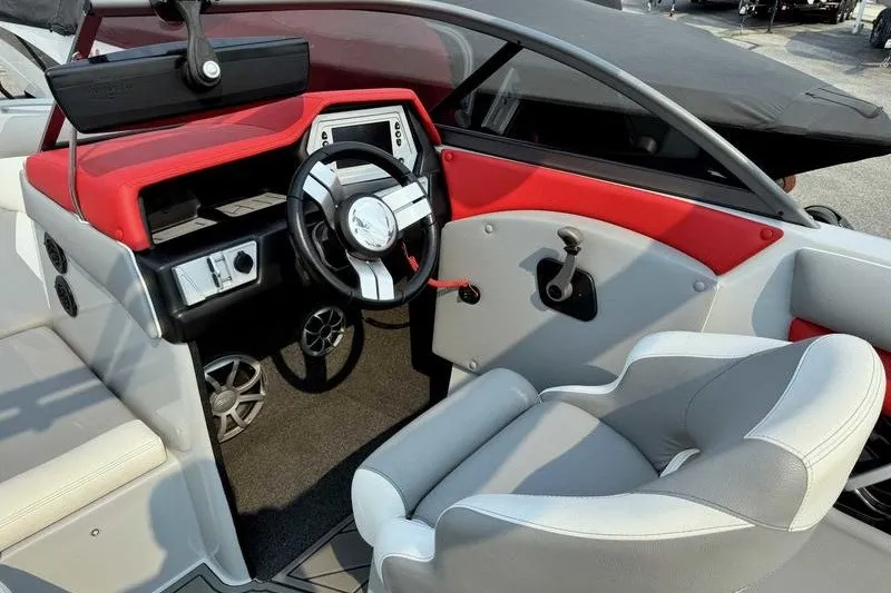 Slide: The Image of 2018 Tigé R21 boat interior with red and gray accents, featuring a modern steering wheel. - 12