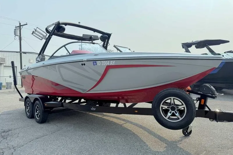 Slide: The Image of 2018 Tigé R21 boat on trailer, gray and red design, parked outdoors. - 8