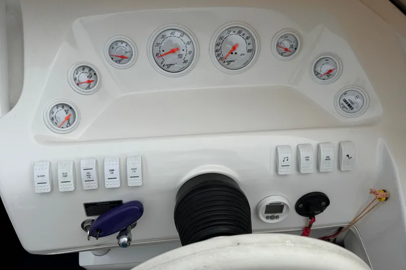 Slide: The Image of Dashboard of a 2006 Nordic Powerboats 25 Rage, featuring gauges and control switches. - 10