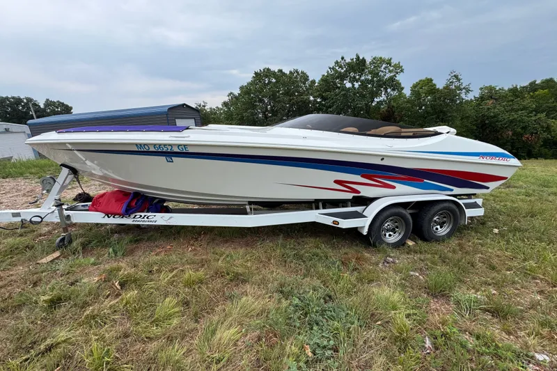 The Image of 2006 Nordic Powerboats 25 Rage on trailer, white with red and blue accents, parked outdoors. - 0