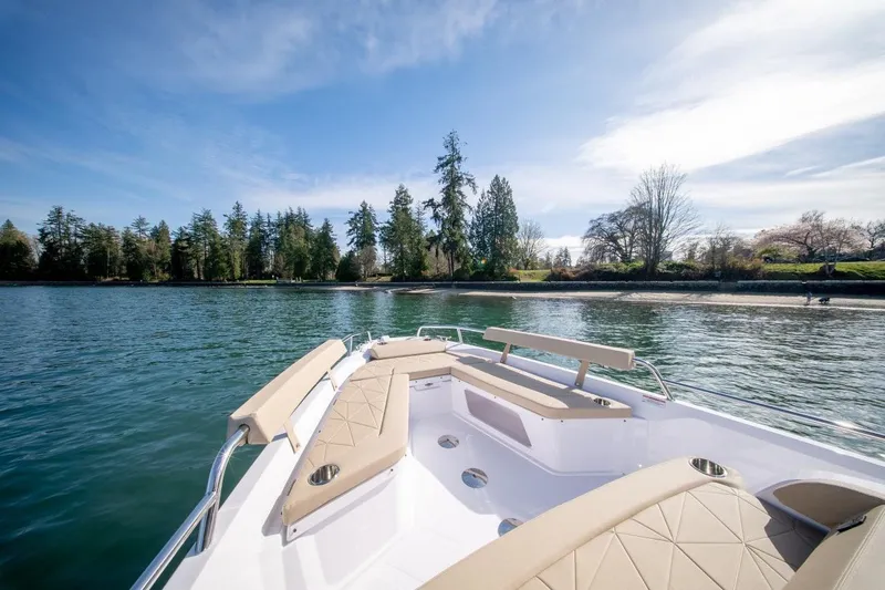 Slide: The Image of 2027 Axopar 29 XC Cross Cabin boat on serene lake with forested shoreline. - 6