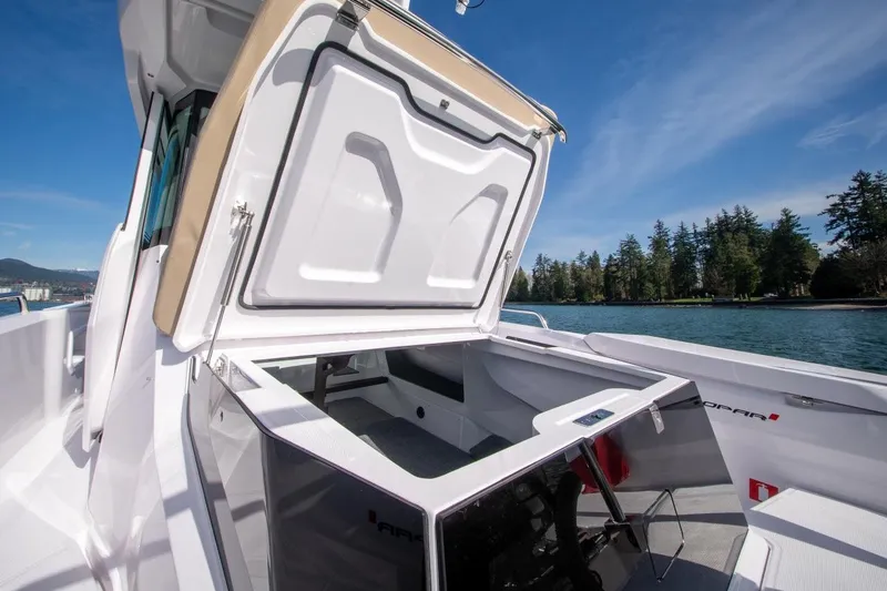 Slide: The Image of 2027 Axopar 29 XC Cross Cabin boat with open storage compartment, scenic water view. - 8