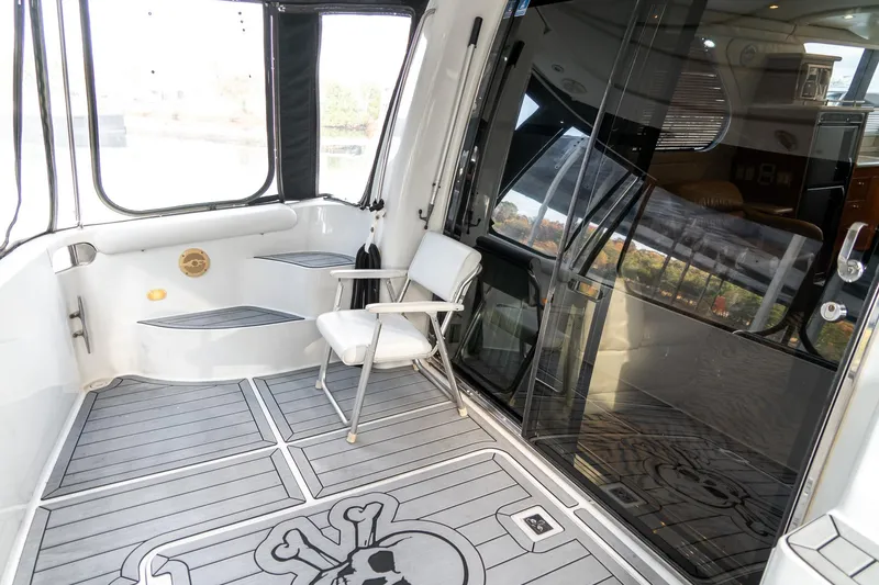 Slide: The Image of 2000 Carver 450 Voyager Pilothouse yacht deck with chair and skull-themed flooring. - 13