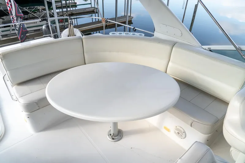 Slide: The Image of 2000 Carver 450 Voyager Pilothouse yacht with white seating and round table on deck. - 26
