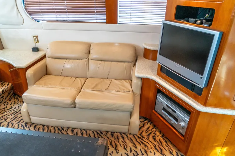 Slide: The Image of Interior of 2000 Carver 450 Voyager Pilothouse with beige sofa and entertainment center. - 32