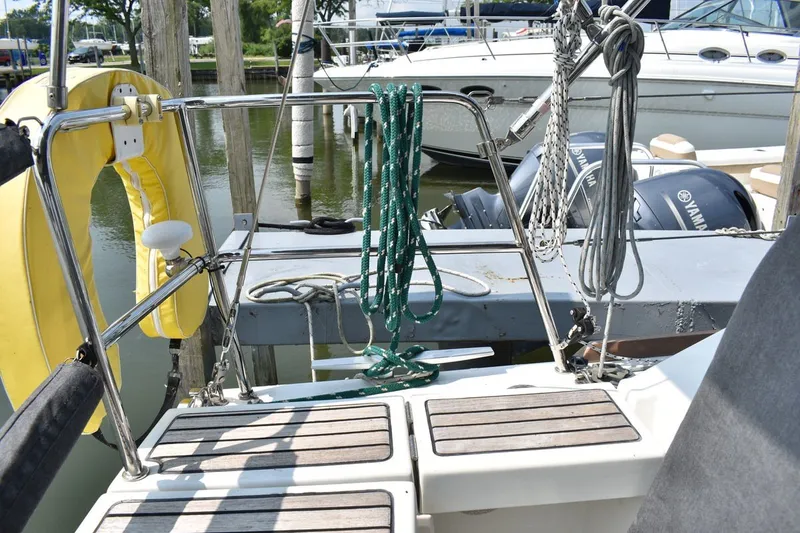 Slide: The Image of Beneteau Oceanis 41.1 sailboat stern with ropes and life preserver, docked at marina. - 8
