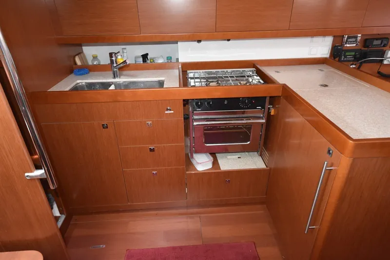 Slide: The Image of Galley kitchen in 2012 Beneteau Oceanis 41.1 yacht with wood cabinetry and stainless steel appliances. - 47