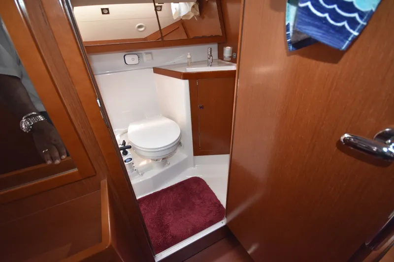 Slide: The Image of Bathroom interior of 2012 Beneteau Oceanis 41.1 yacht with wooden finish and red mat. - 56