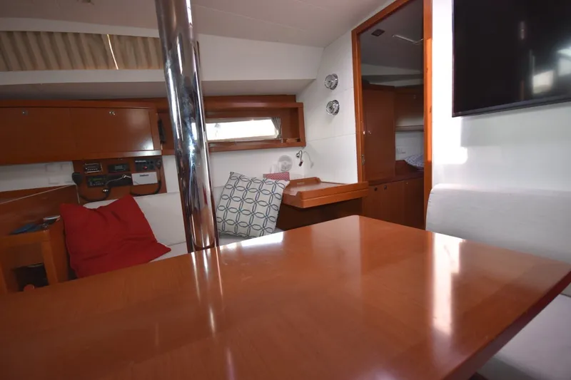 Slide: The Image of Interior of 2012 Beneteau Oceanis 41.1 yacht with wooden furnishings and cozy seating area. - 40