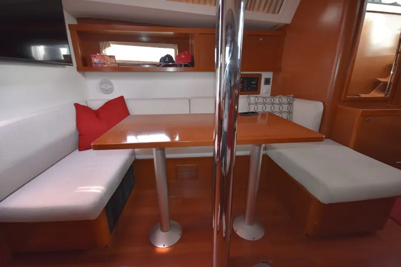 Slide: The Image of Interior of 2012 Beneteau Oceanis 41.1 yacht with cozy seating and wooden table. - 45