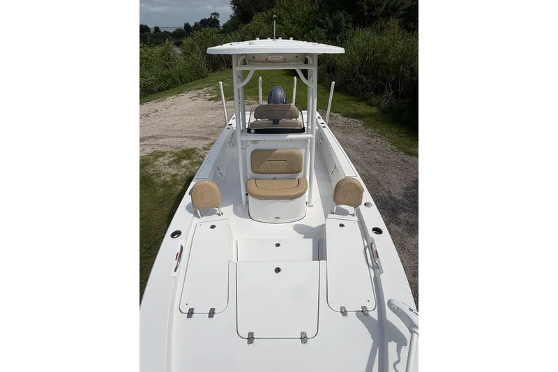 Slide: The Image of 2019 Sportsman Masters 227 Bay Boat with seating and console, parked on grassy area. - 10