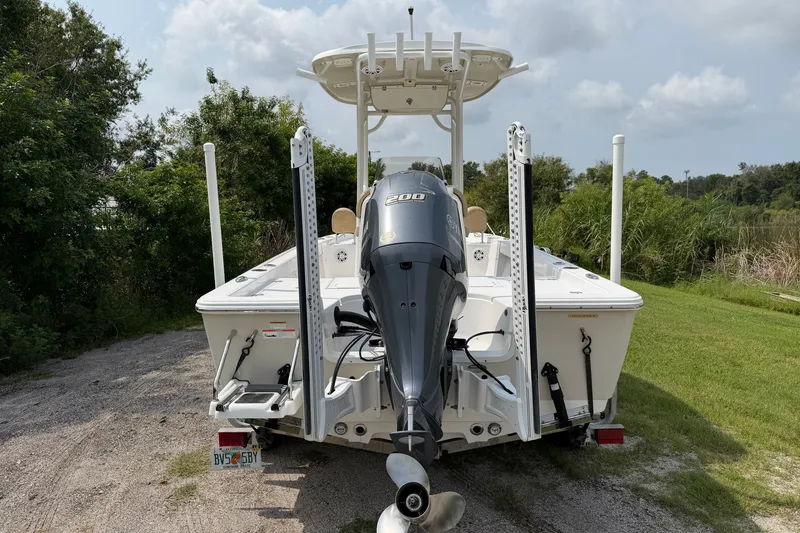 Slide: The Image of 2019 Sportsman Masters 227 Bay Boat with powerful outboard motor, parked on grassy area. - 4