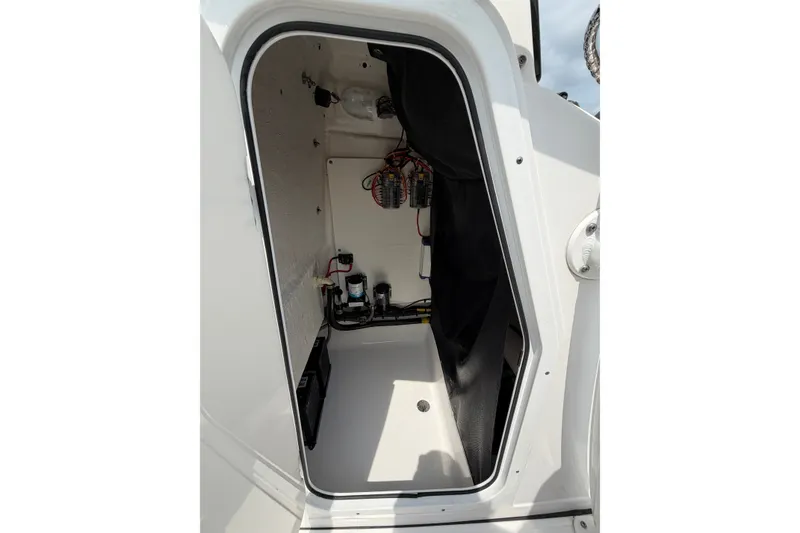 Slide: The Image of 2019 Sportsman Masters 227 Bay Boat interior compartment with wiring and equipment. - 2