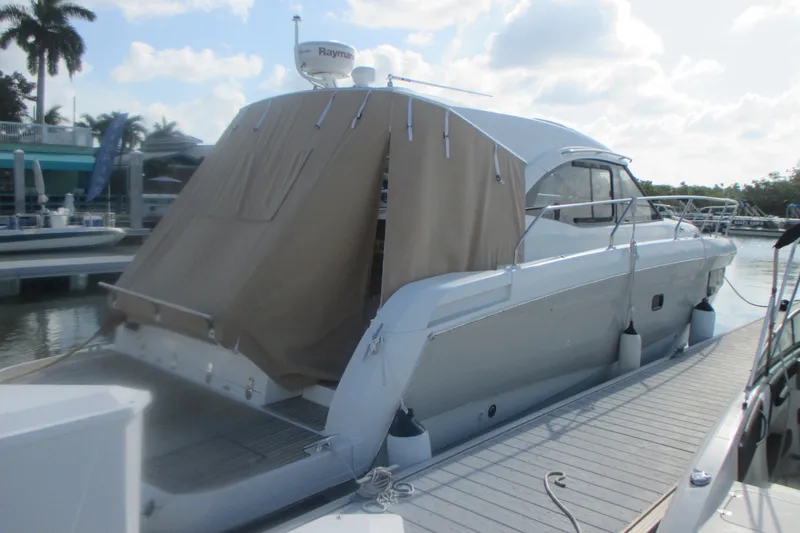 Slide: The Image of 2016 Jeanneau Leader 36 yacht docked with covered stern, sunny marina setting. - 2