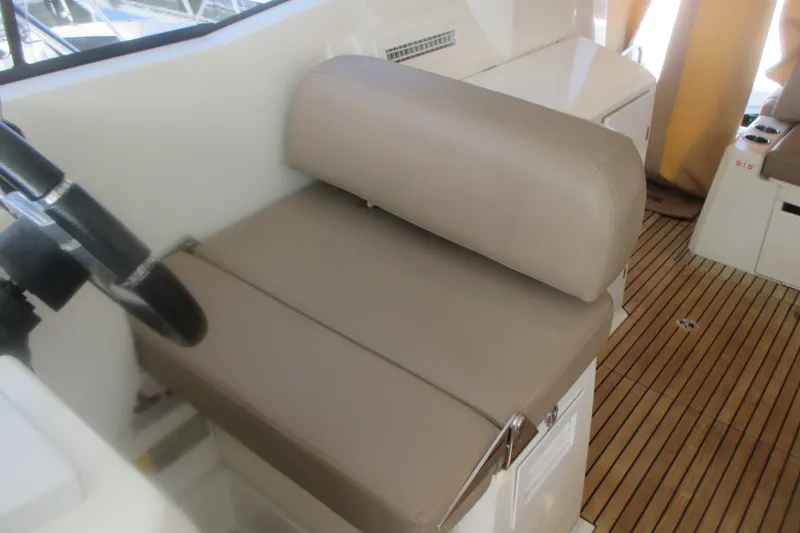 Slide: The Image of Helm seat of 2016 Jeanneau Leader 36 with beige upholstery and wooden flooring. - 17