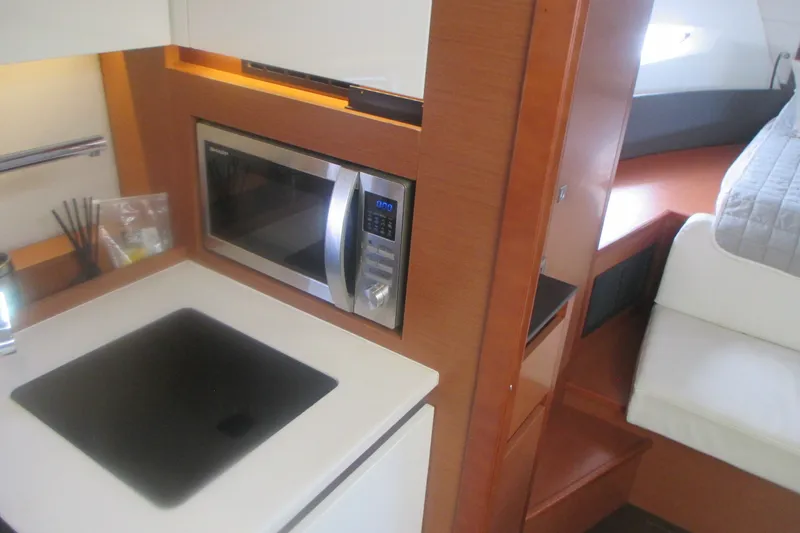 Slide: The Image of Compact kitchen area in a 2016 Jeanneau Leader 36 yacht with microwave and cooktop. - 23