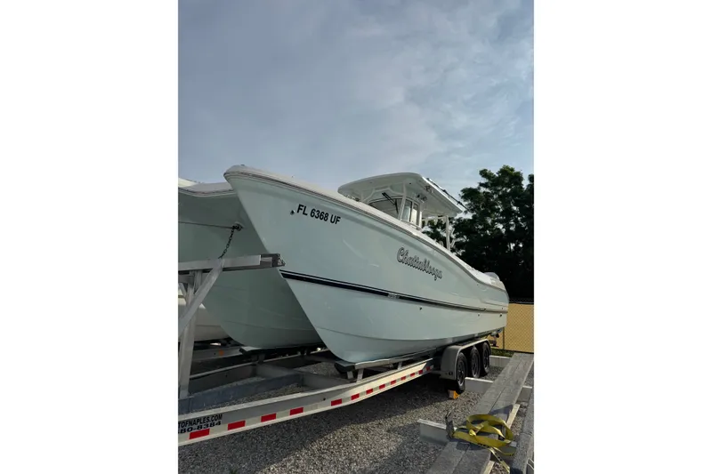 The Image of 2026 World Cat 295 CC boat on trailer, side view with clear sky background. - 0