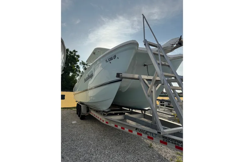 Slide: The Image of 2026 World Cat 295 CC boat on trailer under a clear sky. - 3