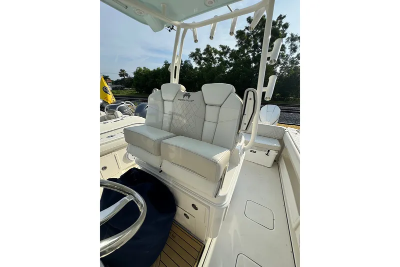 Slide: The Image of 2026 World Cat 295 CC boat interior with plush seating and steering wheel. - 12