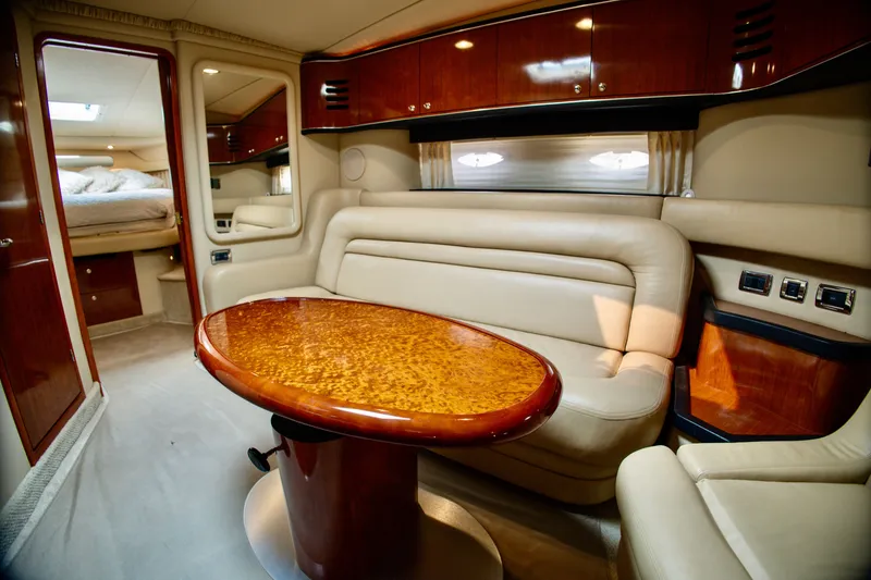 Slide: The Image of Luxurious interior of a 2003 Sea Ray Sundancer 460 with elegant leather seating and wooden table. - 16