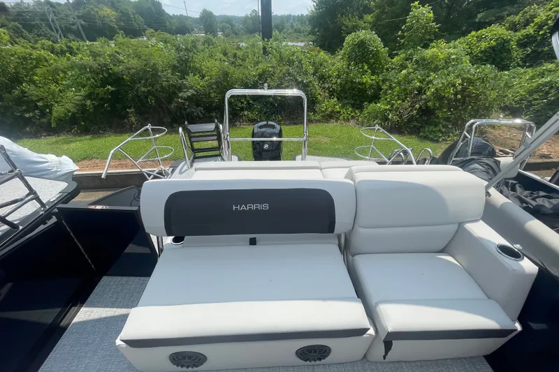 Slide: The Image of 2026 Harris Cruiser 230 SLDH boat with white seating and lush green background. - 9