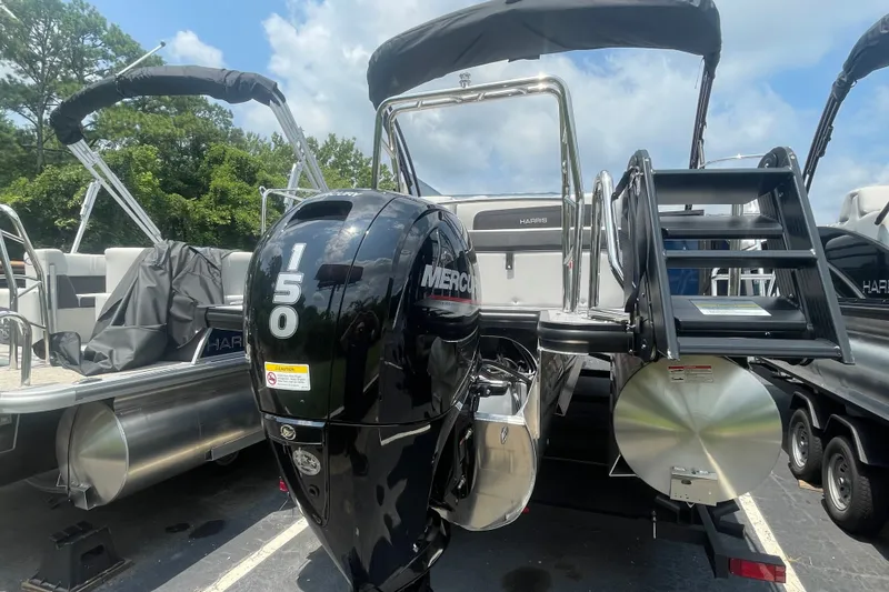 Slide: The Image of 2026 Harris Cruiser 230 SLDH pontoon boat with Mercury 150 engine, parked outdoors. - 19