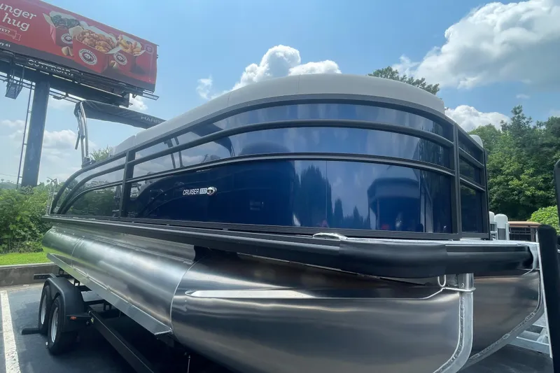 The Image of 2026 Harris Cruiser 230 SLDH pontoon boat on trailer under a sunny sky. - 0