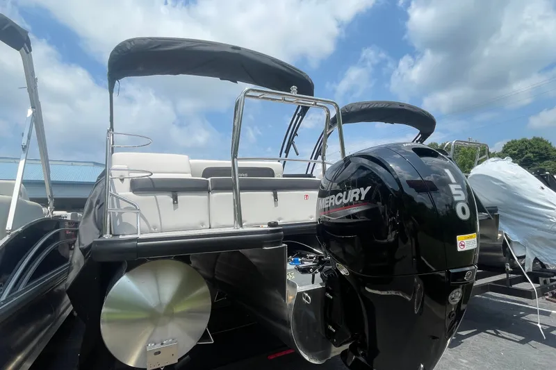 Slide: The Image of 2026 Harris Cruiser 230 SLDH pontoon boat with Mercury 150 engine, docked under blue sky. - 18