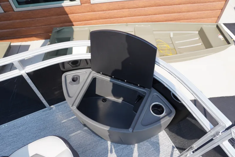 Slide: The Image of 2027 Sun Tracker Fishin' Barge 20 DLX boat with open storage compartment and cup holders. - 5