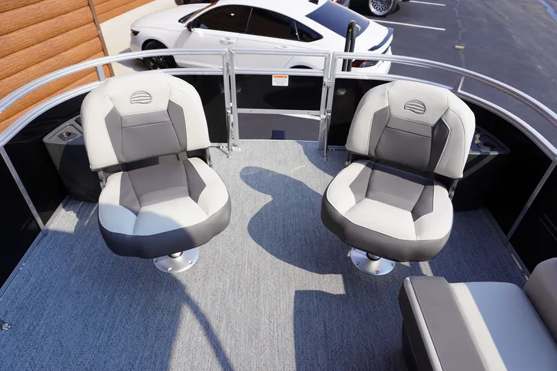 Slide: The Image of 2027 Sun Tracker Fishin' Barge 20 DLX boat seats, gray upholstery, parked white car nearby. - 6