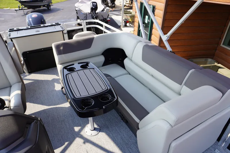 Slide: The Image of 2027 Sun Tracker Fishin' Barge 20 DLX interior with seating and table setup. - 9