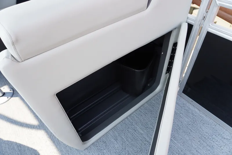 Slide: The Image of 2027 Sun Tracker Fishin' Barge 20 DLX storage compartment with beige upholstery and black interior. - 10