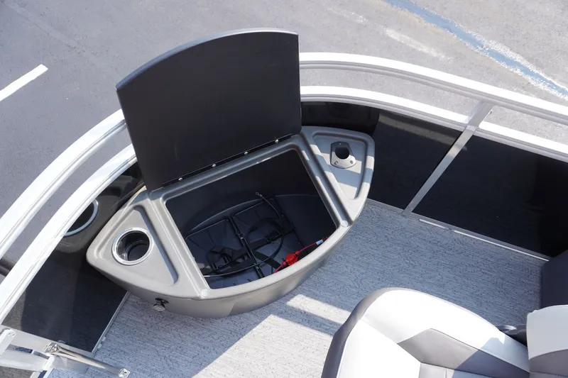 Slide: The Image of 2027 Sun Tracker Fishin' Barge 20 DLX boat storage compartment with open lid and cup holders. - 4