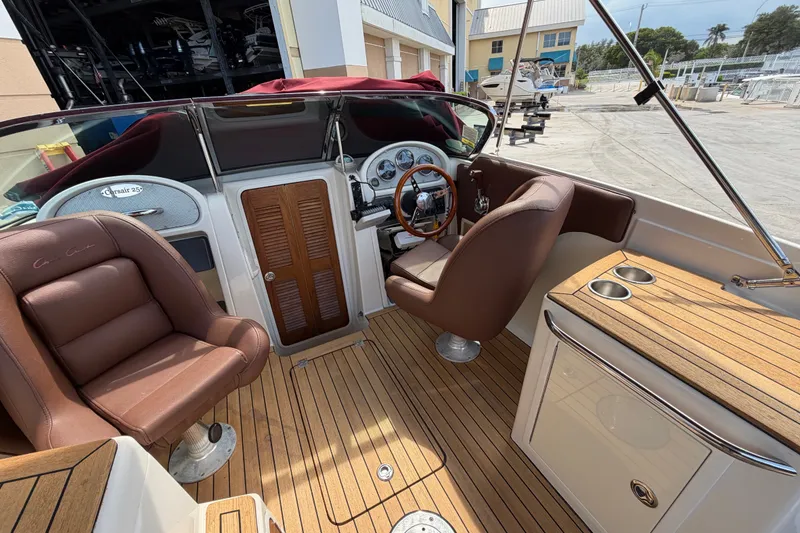 Slide: The Image of 2005 Chris-Craft Corsair 25 boat interior with brown leather seats and wooden dashboard. - 37