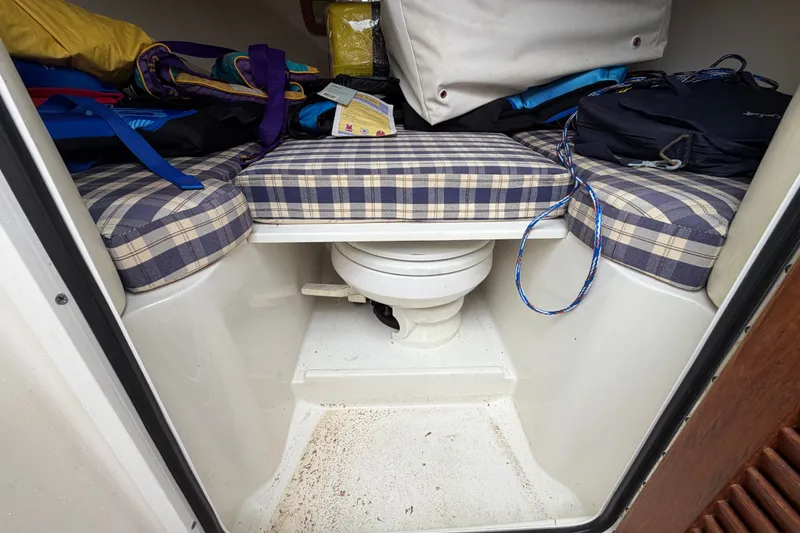 Slide: The Image of 2005 Chris-Craft Corsair 25 cabin interior with plaid cushions and marine toilet. - 46