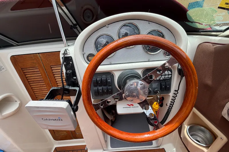 Slide: The Image of 2005 Chris-Craft Corsair 25 dashboard with wooden steering wheel and Garmin navigation system. - 38
