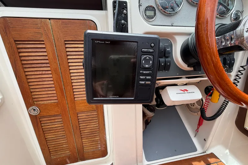 Slide: The Image of 2005 Chris-Craft Corsair 25 dashboard with Garmin GPS and wooden accents. - 33