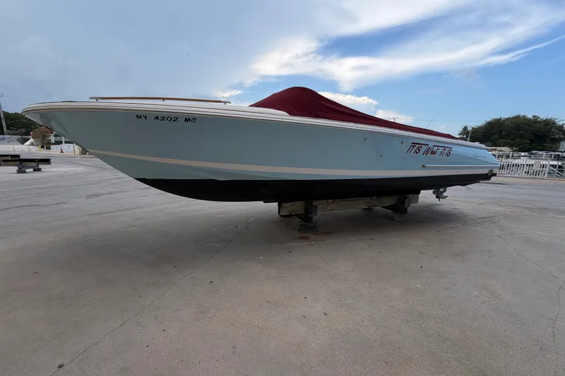 Slide: The Image of 2005 Chris-Craft Corsair 25 boat with cover, displayed on a dock. - 15