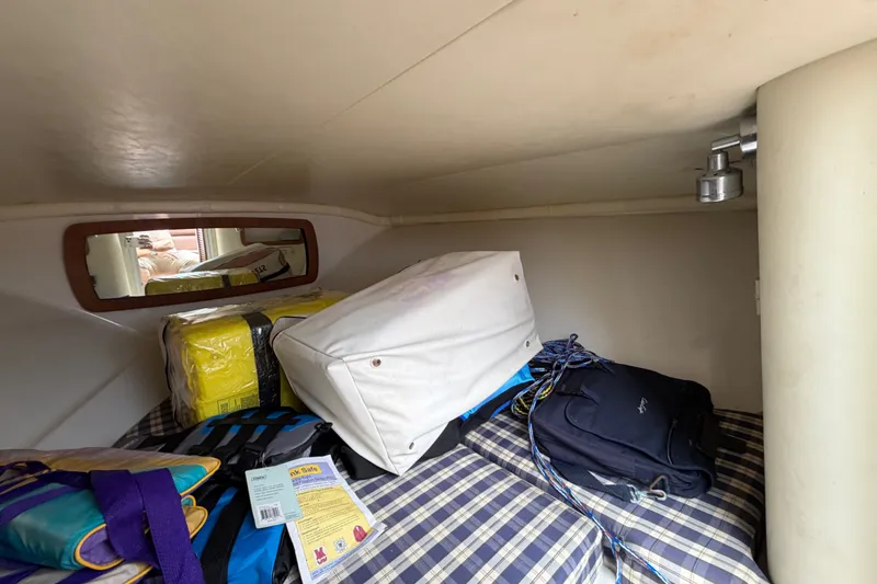 Slide: The Image of Interior cabin of 2005 Chris-Craft Corsair 25 with storage items and plaid bedding. - 48